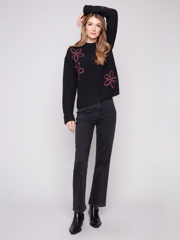 Sophisticated black sweater highlighting a mock neck design with beautiful floral patterns by Charlie B.