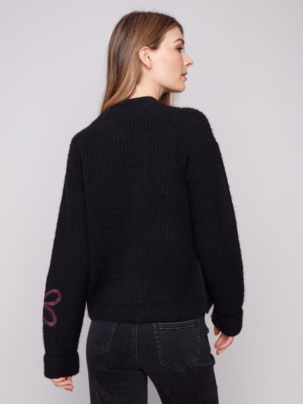 Cozy black sweater displaying exquisite floral soutache embroidery in a relaxed fit style by Charlie B.