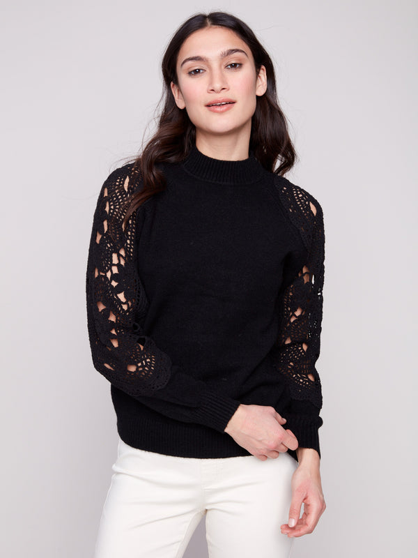 Elegant black sweater featuring a mock neck design, paired with delicate crochet detailing for a sophisticated look by Charlie B.