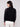 Sophisticated black mock neck sweater adorned with detailed crochet patterns on the sleeves for added flair by Charlie B.