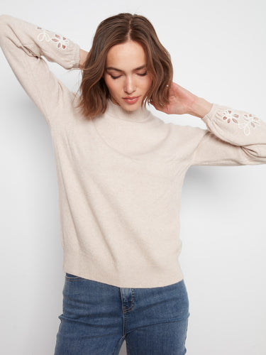 Stylish almond-hued sweater featuring beautiful embroidered flowers on each sleeve, ideal for any occasion by Charlie B.