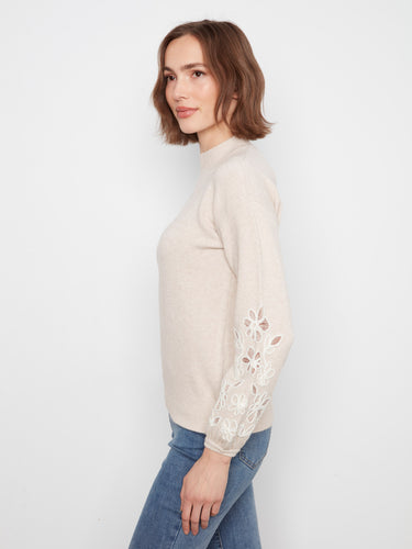 Intricate floral designs adorn the sleeves of this cozy brown mock neck sweater, adding a feminine flair by Charlie B.