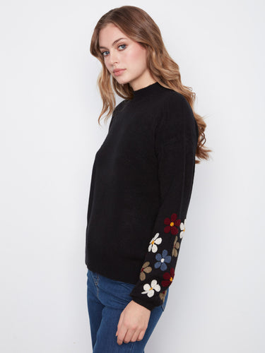 Sweater with a mock neckline and intricate colorful floral embroidery on the sleeves by Charlie B.