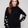 Chic black sweater with a mock neck and charming white hearts, showcasing a stylish drop shoulder design by Charlie B.