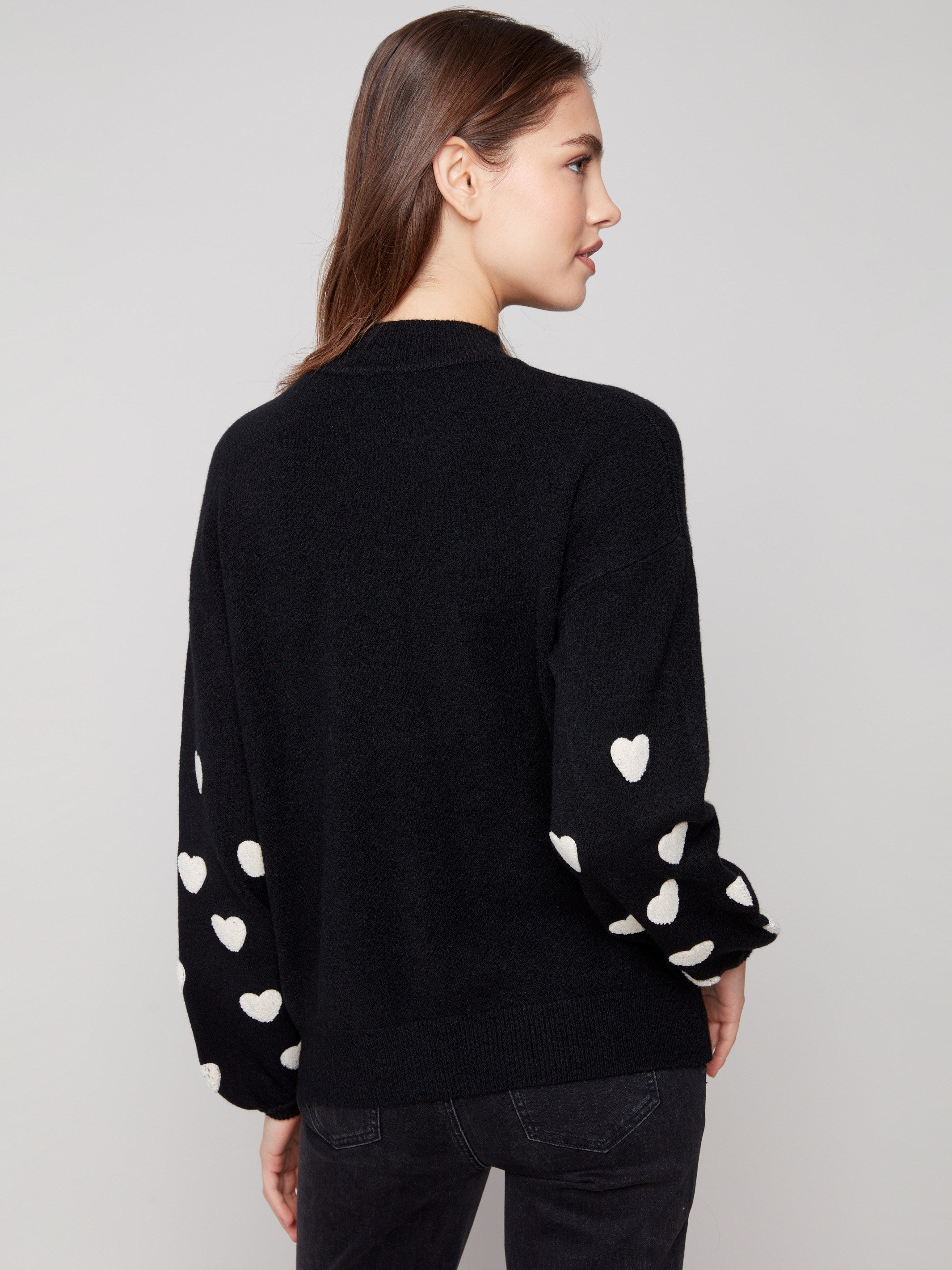 Sophisticated black sweater with intricate white heart embroidery and a comfortable drop shoulder style by Charlie B.