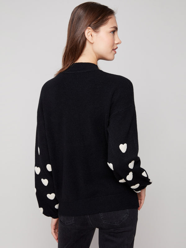 Sophisticated black sweater with intricate white heart embroidery and a comfortable drop shoulder style by Charlie B.