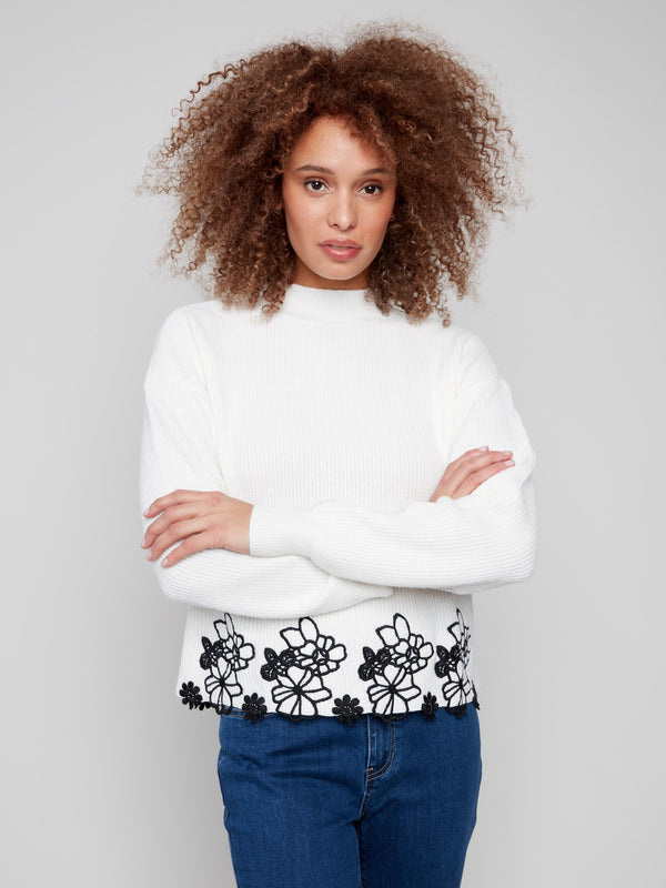 Elegant ecru sweater with long sleeves and floral lace hem, highlighted with a mock neck style by Charlie B.
