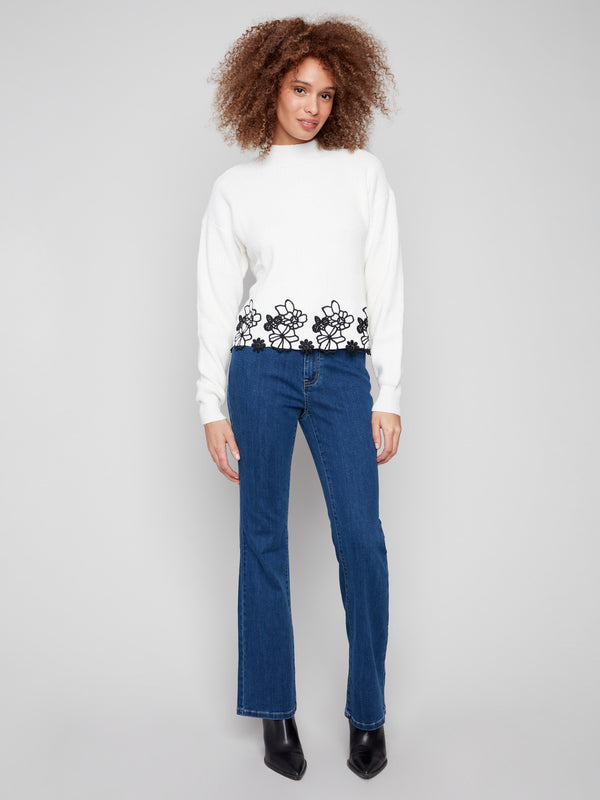 Chic ecru sweater with black floral lace detailing at the hip-length hem, perfect for any occasion by Charlie B.