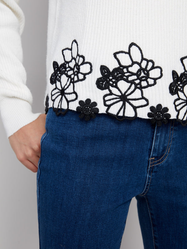 Close-up of the exquisite black floral lace hem on an ecru sweater, offering a stylish touch to your outfit by Charlie B.