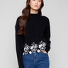 Black sweater featuring a chic drop shoulder design and white floral lace hem, perfect for stylish comfort by Charlie B.