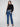 Charming black sweater with hip-length cut and delicate white floral lace detail, offering versatile elegance by Charlie B.