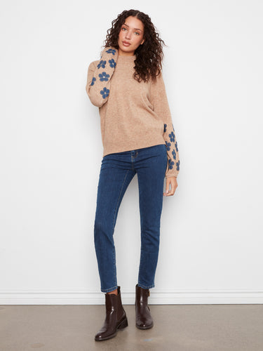 A delightful sweater adorned with floral patches on sleeves, adding elegance to its simple design. By Charlie B.
