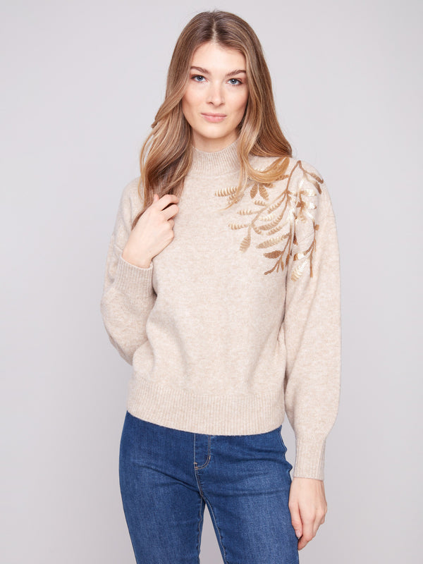 Elegant sweater with mock neck and intricate floral embroidery, adding a touch of sophistication by Charlie B.