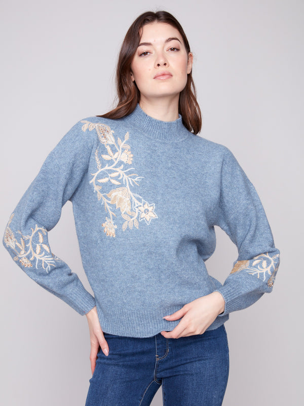 Denim sweater with exquisite floral embroidery and sequins, showcasing a stylish mock neck by Charlie B.