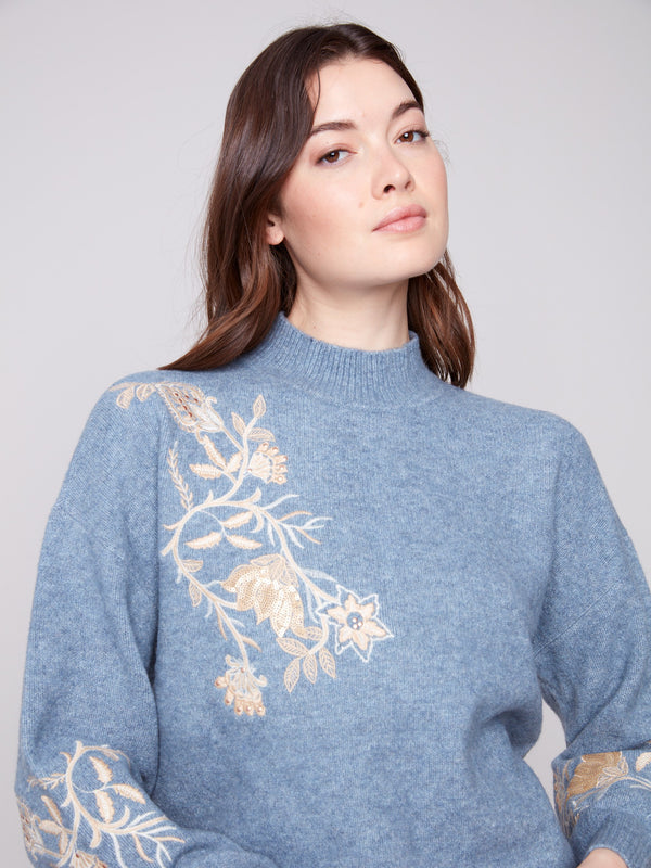 Heather denim knit featuring embroidered floral details, complete with chic drop shoulders by Charlie B.