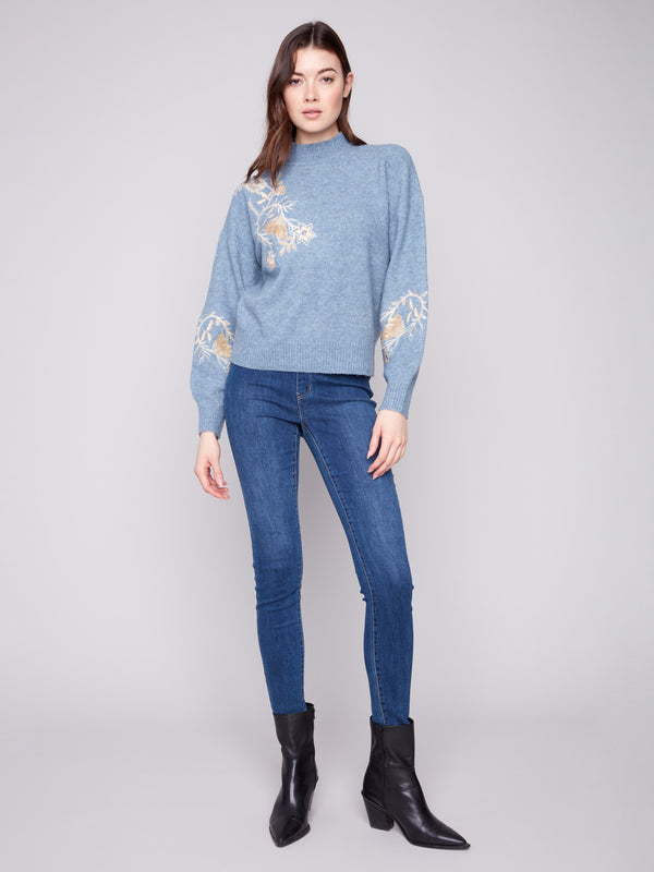 Elegant denim sweater adorned with floral sequin accents and a comfortable mock neck by Charlie B.