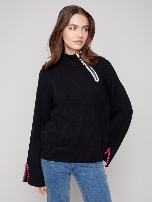 Modern black sweater highlighting intricate open sleeve cuffs for added elegance by Charlie B.