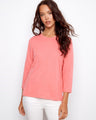 Coral top with a flattering crew neckline, paired with white pants. Perfect for casual outings. Designed by Charlie B.