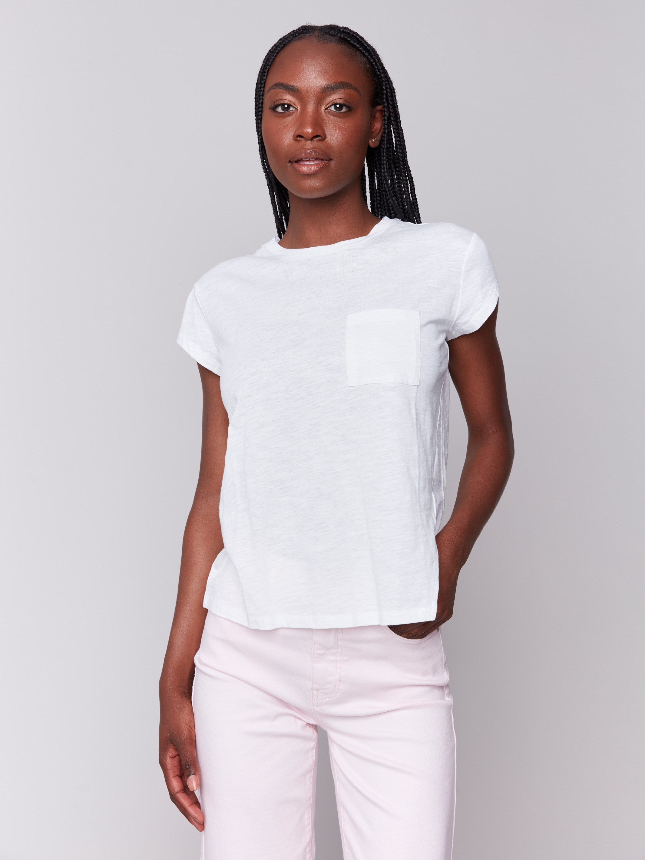 White tee showcasing short sleeves and a chest pocket by Charlie B.