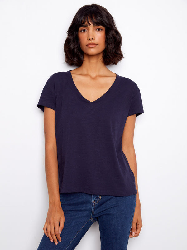 Navy blue top featuring a flattering V-neck, crafted from lightweight cotton for comfort and style. Designed by Charlie B.