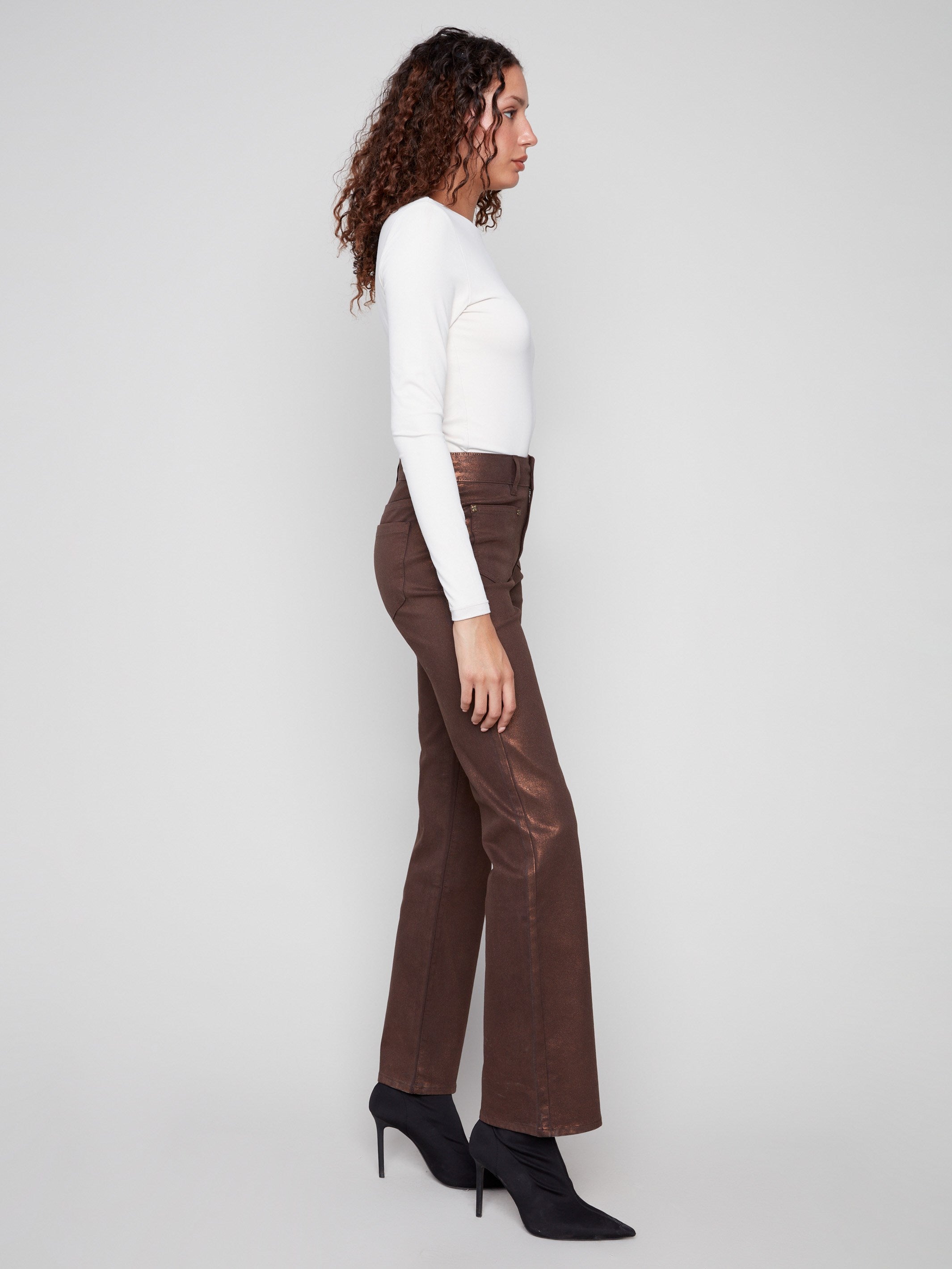Bronze metallic finish pants designed with a flattering flare leg and unique rivet accents by Charlie B.