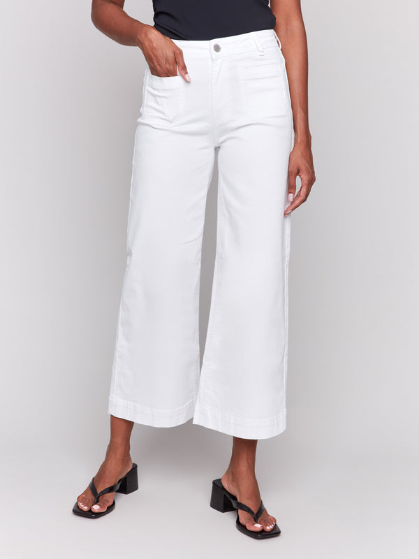 White flare twill pants featuring front patch pockets with a regular rise, button closure by Charlie B.