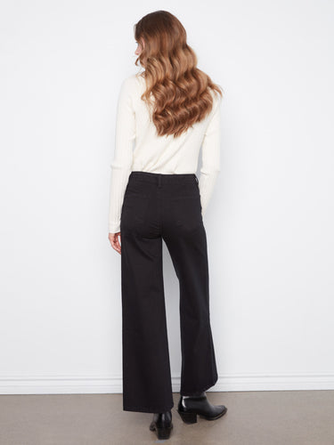 Black wide-leg pants featuring a regular rise, combined with a chic white sweater by Charlie B.