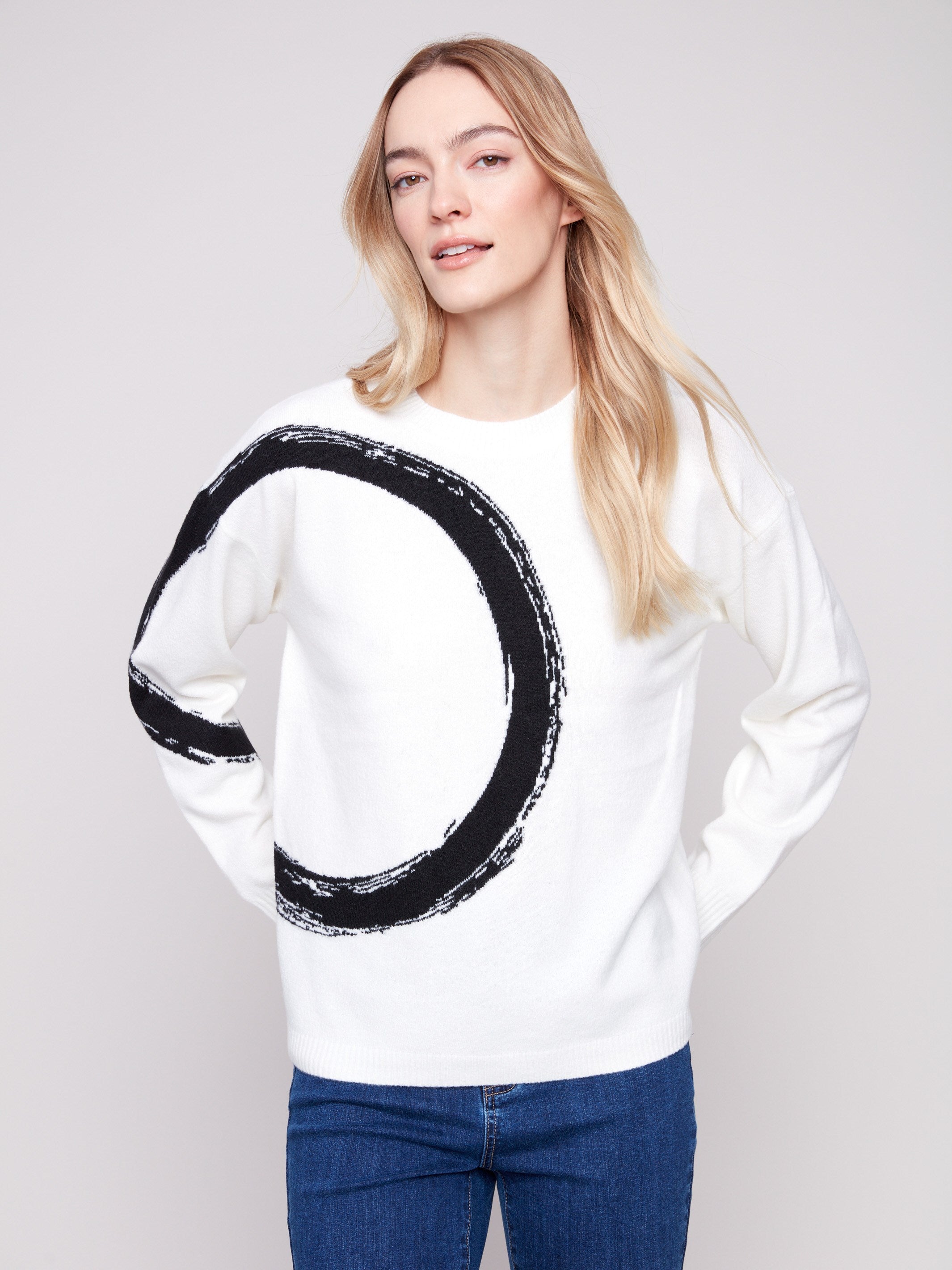 Ribbed cuffs enhance the ecru sweater's design with its bold black abstract circle pattern by Charlie B.