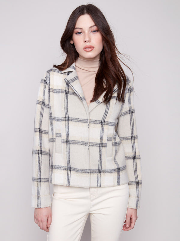 Beige plaid short coat with a tailored collar, hidden snap buttons, and welt pockets. Features long sleeves by Charlie B.