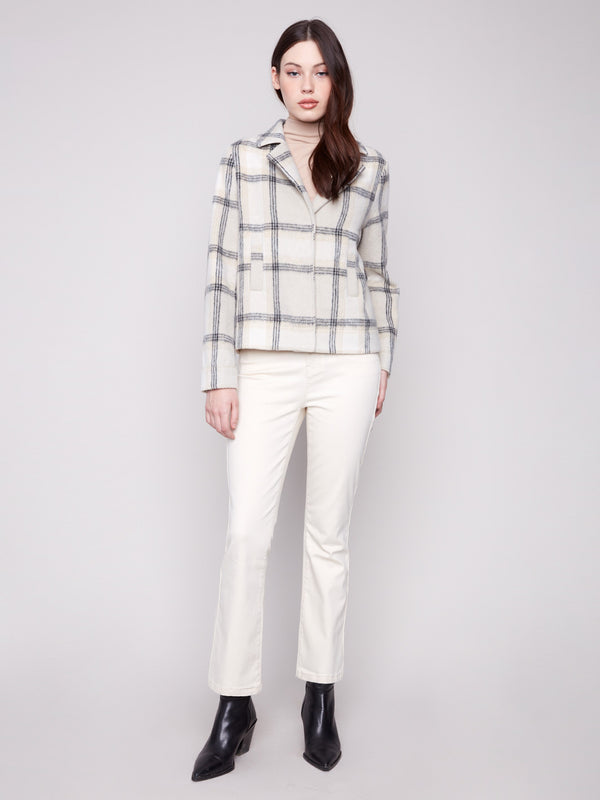 Beige plaid short coat enriched with subtle lurex thread for a hint of shimmer. Includes welt pockets by Charlie B.