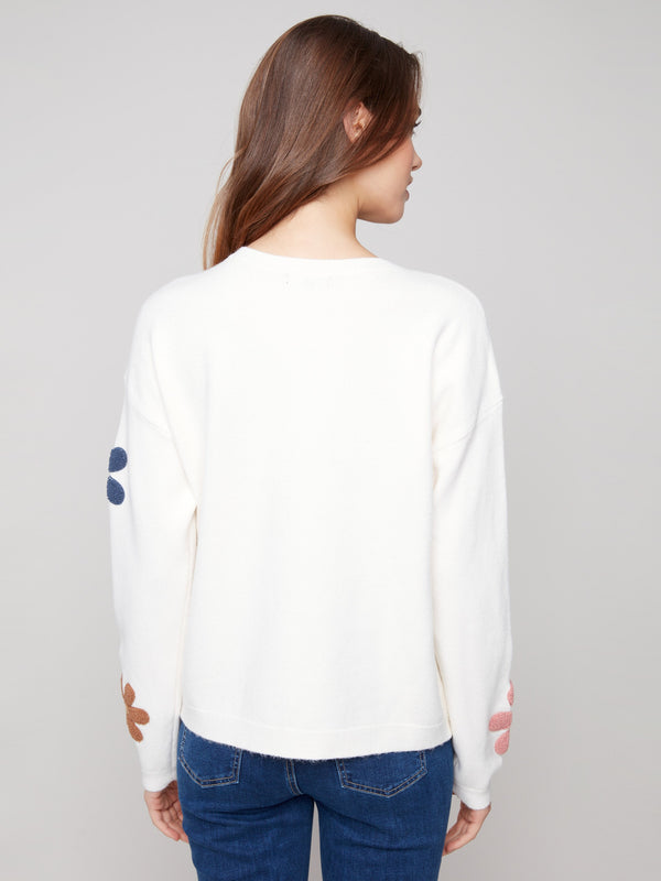 Chic and comfortable, this sweater showcases colorful boucle flowers and a relaxed fit by Charlie B.