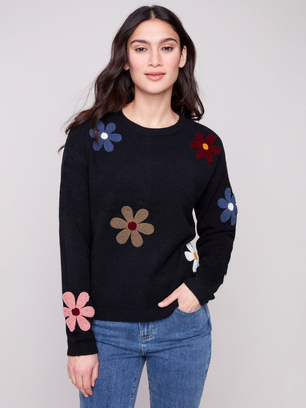 Black plush sweater with a crew neckline adorned with colorful boucle flower patches, creating a vibrant look by Charlie B.