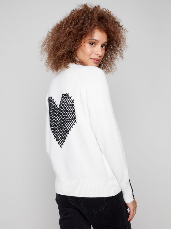 Sweater features soft plush fabric with intricate cross-stitch details along the sleeves for elegance by Charlie B.