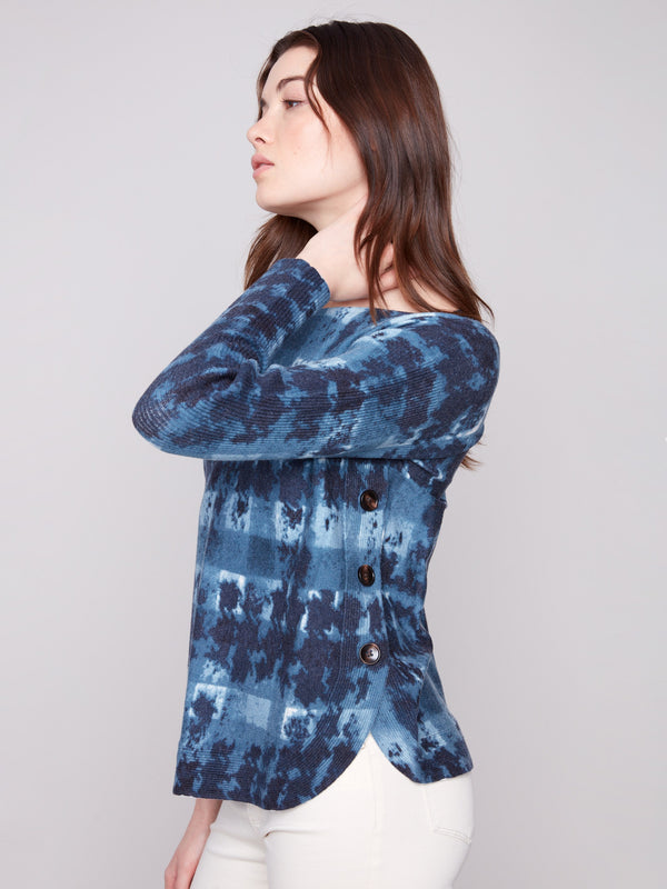 Stylish sweater showcasing side button details and an artistic shadow print design by Charlie B.