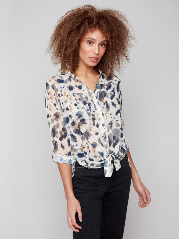 Animal print blouse by Charlie B, featuring a front tie, chest pockets, and side slits, perfect for a chic and stylish look.
