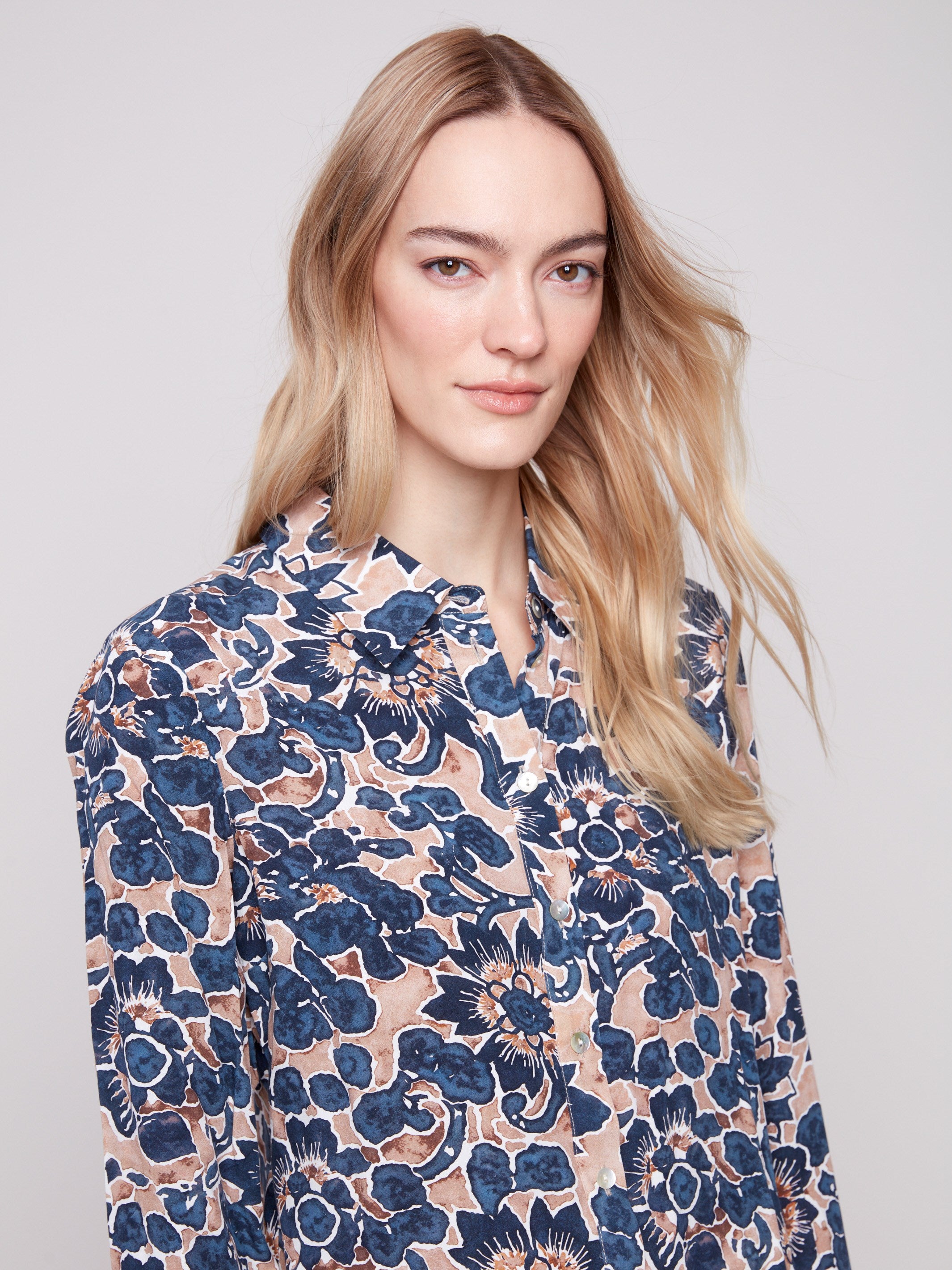 Long sleeve shirt with intricate floral patterns in blue and cream shades, featuring button-down design and foldable cuffs by Charlie B.
