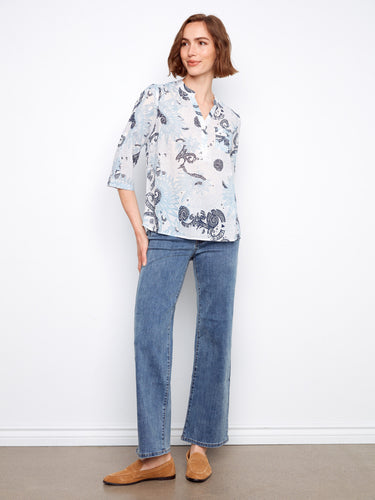 Stylish Henley neckline adds a touch of elegance to this floral-patterned top, worn with comfortable denim. By Charlie B.