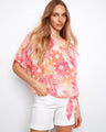 Model in a floral cotton gauze blouse with short dolman sleeves, adding a breezy touch to the look by Charlie B.