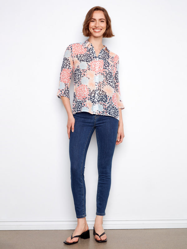 Stylish floral blouse with adjustable roll-up sleeves, perfect for versatile wear. By Charlie B.