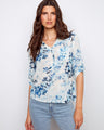 Floral blouse with a Henley neckline, showcasing a blend of blue and white hues. Perfect for casual outings. By Charlie B.