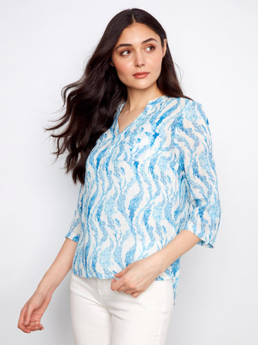 Chic blue blouse with adjustable roll-up sleeves, allowing versatile styling options for any occasion. By Charlie B.