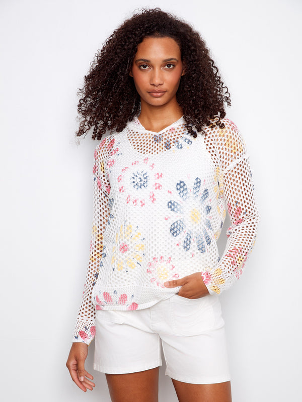 Embrace comfort and style with this trendy crochet top showcasing vibrant floral accents and relaxed fit sleeves. By Charlie B.