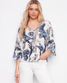 A blouse with a striking paisley pattern, featuring wide 3/4 sleeves and decorative buttons by Charlie B.
