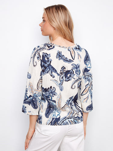 A vibrant abstract print blouse featuring front decorative buttons and ladder stitch detail by Charlie B.