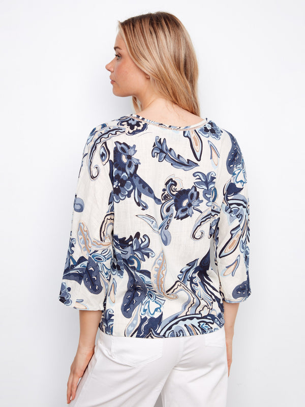 A vibrant abstract print blouse featuring front decorative buttons and ladder stitch detail by Charlie B.