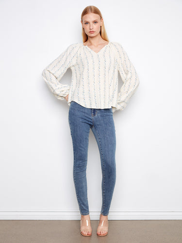 This blouse showcases long raglan sleeves, offering a relaxed fit and chic style. Ideal for pairing with jeans by Charlie B.
