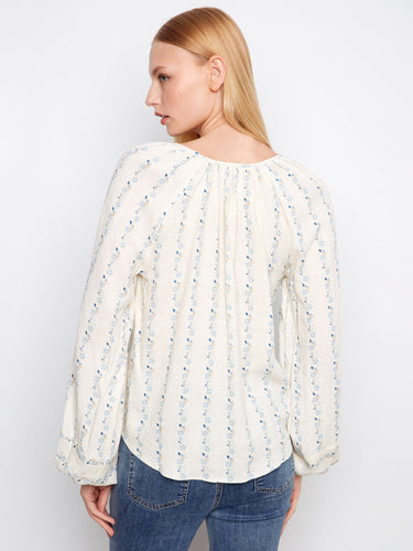 A charming floral pattern adorns this blouse, adding subtle elegance to your everyday wardrobe by Charlie B.