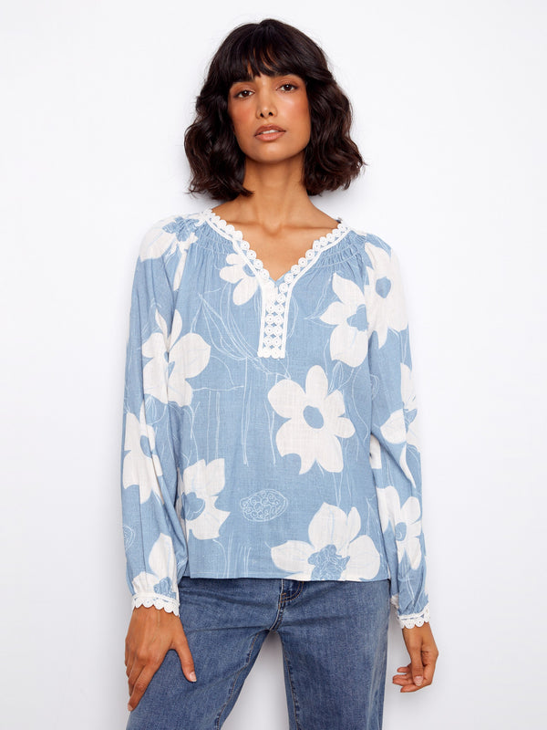 Elegant blue blouse highlighted by its unique notch neckline, creating an effortlessly stylish appearance by Charlie B.
