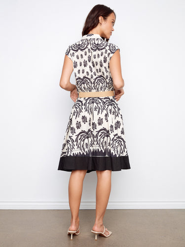 Stylish black and white dress featuring knee-length cut, tailored neckline, and convenient two pockets by Charlie B.