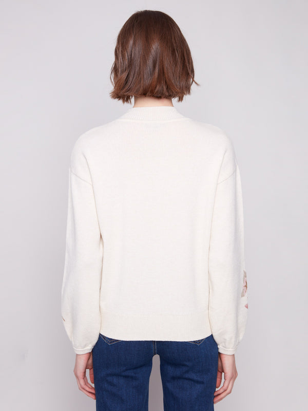 Elegant sweater crafted with long balloon sleeves and floral motifs by Charlie B.